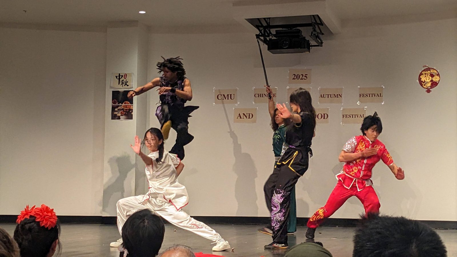 Several performers mid-routine beneath the Mid-Autumn and Global Food Festival banner