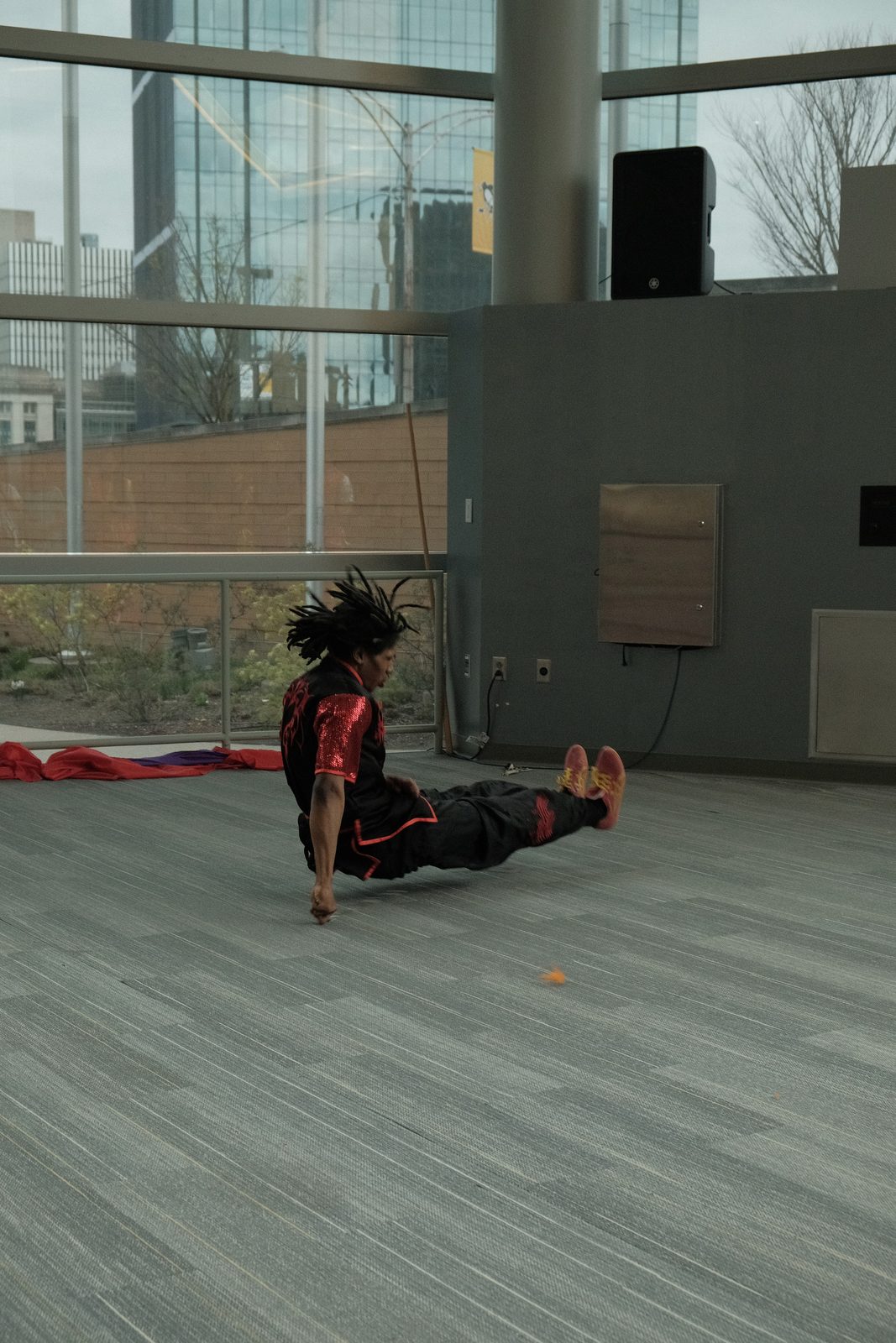 A performer dropping into a low sweeping kick on the arena floor